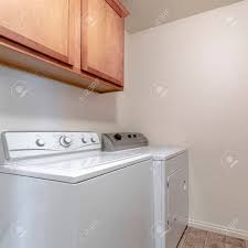 Check spelling or type a new query. Square Laundry Interior With Washer And Dryer Below Fitted Wall Mounted Wooden Cabinets In Close Up Stock Photo Picture And Royalty Free Image Image 149188670