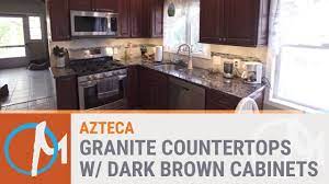 But lately it is used with dark cabinetry as well. Azteca Granite Counters With Dark Brown Cabinets Youtube
