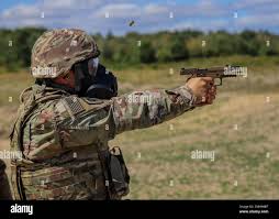 U.S. Army Staff Sgt. Jonathan Over, a V Corps historian, fires the M17  pistol at a target during an weapons qualification, July 27, 2022, in  Zlotkowo, Poland. V Corps Soldiers conducted these