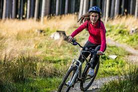 Girl Wearing Protective Gear Riding Bike On Forest Trail Stock Photo -  Download Image Now - iStock