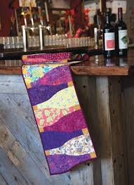 One Wine Bottle Shape And A Variety Of Prints And Batiks Is All You Need To Make This Table Runner Pattern Quilted Table Runners Patterns Quilted Table Runners