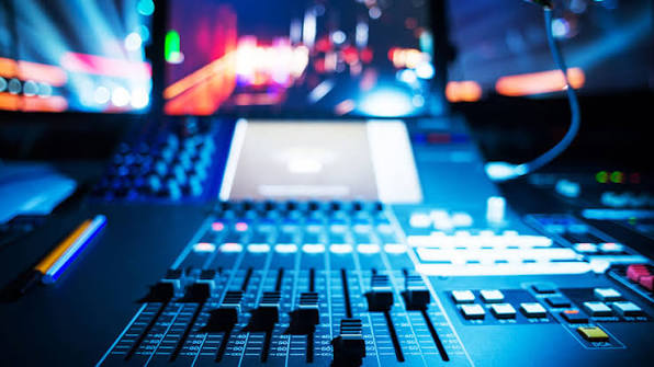 Estúdio moderno de produção de áudio cinematográfico com sintetizadores e estações de trabalho digitais