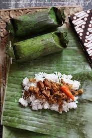 coconut rice filling wrapped in banana leaf arem arem is one of unique dish from indonesia it is a filling food presentation coconut rice banana leaf plates