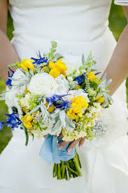 The wiry stems of ageratum and pincushion flowers that rise above the roses, calla lilies, and hydrangeas in this pastel purple and blue bouquet add a touch of whimsy. Yellow White And Blue Bridal Bouquet
