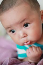 A baby with a toothbrush in its mouth. Baby cute happy, emotions.