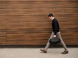 Premium Photo | Boring everyday work routine. business man walking in the city his head down. tired of plain office job. wood texture background. free space concept