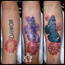 An artist magically turned this putrid butterfly tattoo into a gorgeous pair of winged insects. A Butterfly Covers An Old Name Tattoo And The Flowers Added As Well As Recolored Old Flower Www Misha Art Com Cover Up Tattoos Tattoos Old Tattoos