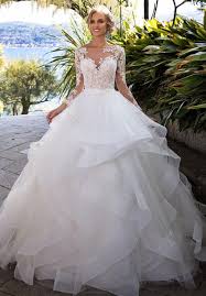 Luxurious beaded lace cascades over a shimmering metallic underlay in this majestic ball gown wedding dress. Elegant Appliques Full Sleeve White Ball Gown Wedding Dresses Tulle Bridal Tulle Wedding Dress Ballgown Tulle Wedding Dress Ruffle Wedding Dress