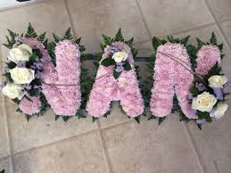 Made with stunning artificial silk white carnations and additional roses in a colour of your choice, with added butterfly and poly ribbon with name card for that special finishing touch with an option to add a name on a poly ribbon at £2. Nans Funeral Flowers