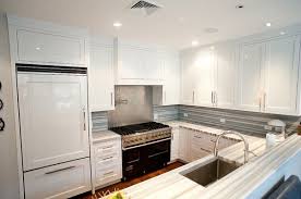 Contemporary Kitchen With White Shaker Kitchen Cabinets Stone Counter Tops Pot Filler And Glossy Wh Countertops Modern Shaker Kitchen Shaker Kitchen Cabinets