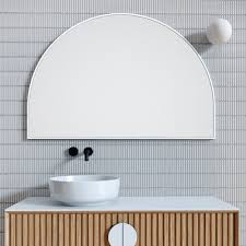 A white and gray octagon vanity chair sits at a white makeup vanity adorned with brass hardware and positioned beneath a gold framed mirror flanked by camille sconces. Arch Metal Framed Bathroom Mirror White 80cm X 120cm Luxe Mirrors