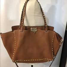 Valentino's tan leather shoulder bag with silver pyramid stud embellishment is a luxurious carryall. Valentino Bags Valentino Brown Grained Leather Rockstud Bag Poshmark