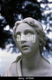 Face of female statuary staring vacantly under Southern tree Stock Photo