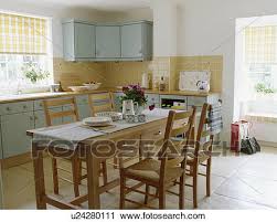 While lending a classic feel and adding a timeless look that your kitchen deserves, boconcept's dining table and chairs range could serve as the perfect fit for all tastes, styles, and spaces. Simple Wooden Table And Chairs In Cottage Kitchen Dining Room With Turquoise Units Stock Image U24280111 Fotosearch