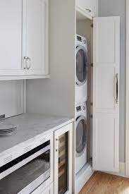 First, you have plenty of options. Galley Style Kitchen Featuring Hidden Stacked Washer And Dryer In A White Cabinet Finished With A Chro Laundry In Kitchen Hidden Laundry Rooms Apartment Washer