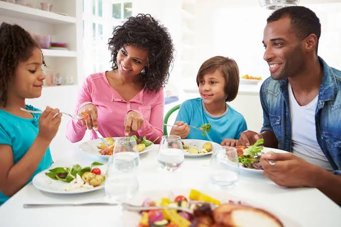 A happy family cooking breakfast-for-dinner together in a bright modern kitchen