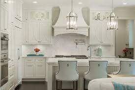 If you want to keep your kitchen looking bright, clean, and uncluttered, you can keep the decor to a minimum, and focus on accessories that are in various shades of white and cream. White Herringbone Backsplash With Off White Kitchen Cabinets Transitional Kitchen