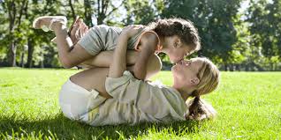 Couple sitting and hugging on the bed. Doctor Says Kissing Kids On The Lips Confuses Them Sexually Suggests Never Kissing On The Mouth