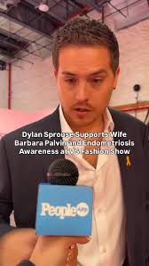 Husband of the year energy! 🩷#DylanSprouse brought the love to the  #VSFashionShow pink carpet, before his wife #BarbaraPalvin hit the catwalk.  He even gave a PEOPLE reporter a pin to support ...