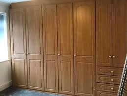 White painted wardrobe with a pair of open doors showing walnut interiors with led lighting, a clothes rail, and 3 bottom drawers with steel bar handles. Spray Painting Your Outdated Fitted Wardrobe Upvc Sprayers