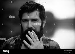 Man with beard smoking cigar Black and White Stock Photos & Images