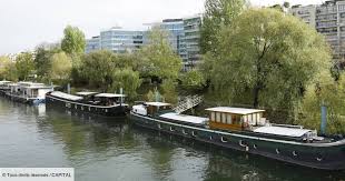 Une péniche bien chargée je pense en tout cas elle navigue au raz des vagues un petit bateau aussi juste avant qui a l'air de profiter du paysage Vivre Sur Une Peniche Un Reve Couteux Capital Fr