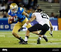 UCLA wide receiver Jalen Ortiz, left, fends off Colorado defensive back Jered  Bell (21) after a