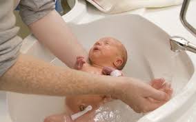 Baby taking bath in the kitchen sink. Transitioning Your Child From A Baby Bath Tub