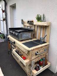Reclaim the wood pallets from your thrift store to make this outdoor dining table. Recycled Wood Pallet Kitchen Outdoor Idea Outdoorkuche Kitchen Outdoor Outdoorkuche P Pallet Outdoor Kitchen Ideas Pallet Kitchen Diy Outdoor Kitchen