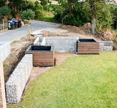Gartenbauprojekt Modernes Hochbeet Zur Hangabstutzung Mit Holzverkleidung Und Kiefernbepflanzung Frei Geplant Planung Umsetzung Und Bepflanzung Holz Beton K In 2020 Modern Landscaping Modern Garden Modern Garden Design