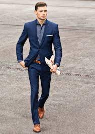 Discover unique designers fashion at laramody.com. Crisp Slim Navy Suit With Brown Cap Toe Shoes Brown Leather Belt Light Blue Shirt White Cotton Pocket Square Lape Blue Suit Men Mens Outfits Mens Fashion Suits