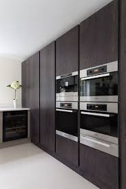 Installed to sit flush with fitted units, integrated microwave ovens reduce visual clutter and free up counter space to make cooking and food preparation easier. Stained Oak Larder Units And Oven Housing Miele Appliances Modern Kitchen Modern Kitchen Design Modern Kitchen Ovens