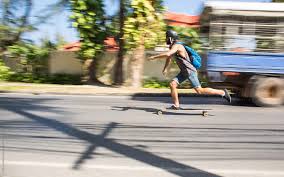 Action Shot Of A Longboarder Skating On An Urban Road Slight Motion Blur By Jovo Jovanovic Stocksy United