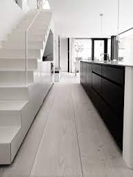 wide lime washed floorboards black kitchen units white stairs minimalistische kuche treppe weiss