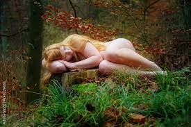 Reizendes junges Mädchen liegt nackt auf im Wald auf einem abgesägten  Baumstumpf, bedeckt mit ihren langen roten Haaren Stock-Foto | Adobe Stock