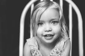 natural light black and white portrait of girl sitting in a chair by  Tiffany Kelly
