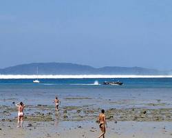 Image of California beach with a small tsunami wave in the distance