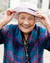 This is our friend Dorothy Quock photographed last year in San Francisco  Chinatown. She made this vest out of quilted potholders and her hat out of  gifted Chinatown ornaments. Though this look
