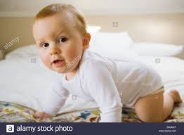 Portrat Eines 10 Monate Alten Baby Jungen Auf Einem Bett Kriechen Stockfotografie Alamy