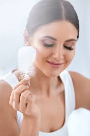 Cuidados De Beleza Para a Pele. Mulher a Tocar Na Pele Macia Do Rosto Com  Uma Pena Foto de Stock