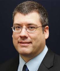 WMU's President, Dr. Edward Montgomery, driving the Bronco Baja vehicle in  front of The College of Engineering and Applied Sc