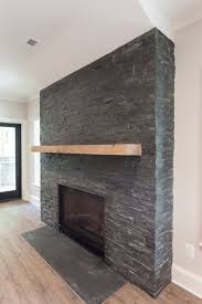 Let us help you find and install the perfect stone fireplace for your home. Black Stacked Stone Fireplace With Reclaimed Natural Wood Mantel In Walk Out Basement Of Of Custo Stacked Stone Fireplaces Stone Tile Fireplace Stone Fireplace