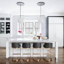 Black and gold themed kitchen. Gold And Black Stools At White Kitchen Island Transitional Kitchen