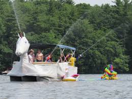 From the green sheeting we cut out the eyes, mouths, eyebrows and laugh/cry lines to layer on top of the purple and gold. Boat Parade Pawtuckaway Lake Improvement Association
