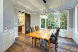 I love, love, love a dining room with high. Light And Spacious Dining Room Interior In A Luxury Custom Built Home White Wainscoting Surrounding A Light Wood Dining Table And Grey Parsons Dining Chairs Placed Under Rectangular Tray Ceiling Stock Photo