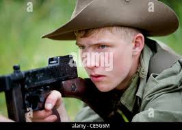 Ein Nachspieler im Zweiten Weltkrieg in der Uniform der deutschen Armee  feuert sein Gewehr ab. Militärische Wiedererwirkung. Mündungsblitz. Das  Heer Living History Gesellschaft Stockfotografie