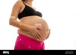 Pregnant Women With Big Belly Caressing Her Unborn Baby While Dressed Only In Bra And Shorts Stock Photo Alamy