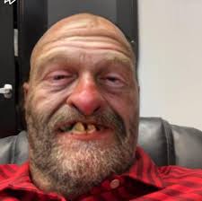 Man in red car approaches child at ball field