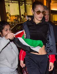 The model wears long honey blond hair in a retro style with short bangs and crimped hair. Bella Hadid Accosted By Woman With Palestine Flag In Ny Daily Mail Online