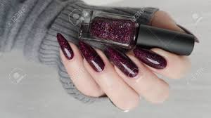 This beautiful nail polish for dark skin offers a smooth and intense finish with just a single swipe. Woman S Hands With Long Nails And A Dark Red Burgundy Manicure Holds A Bottle Of Nail Polish Stock Photo Picture And Royalty Free Image Image 152162269